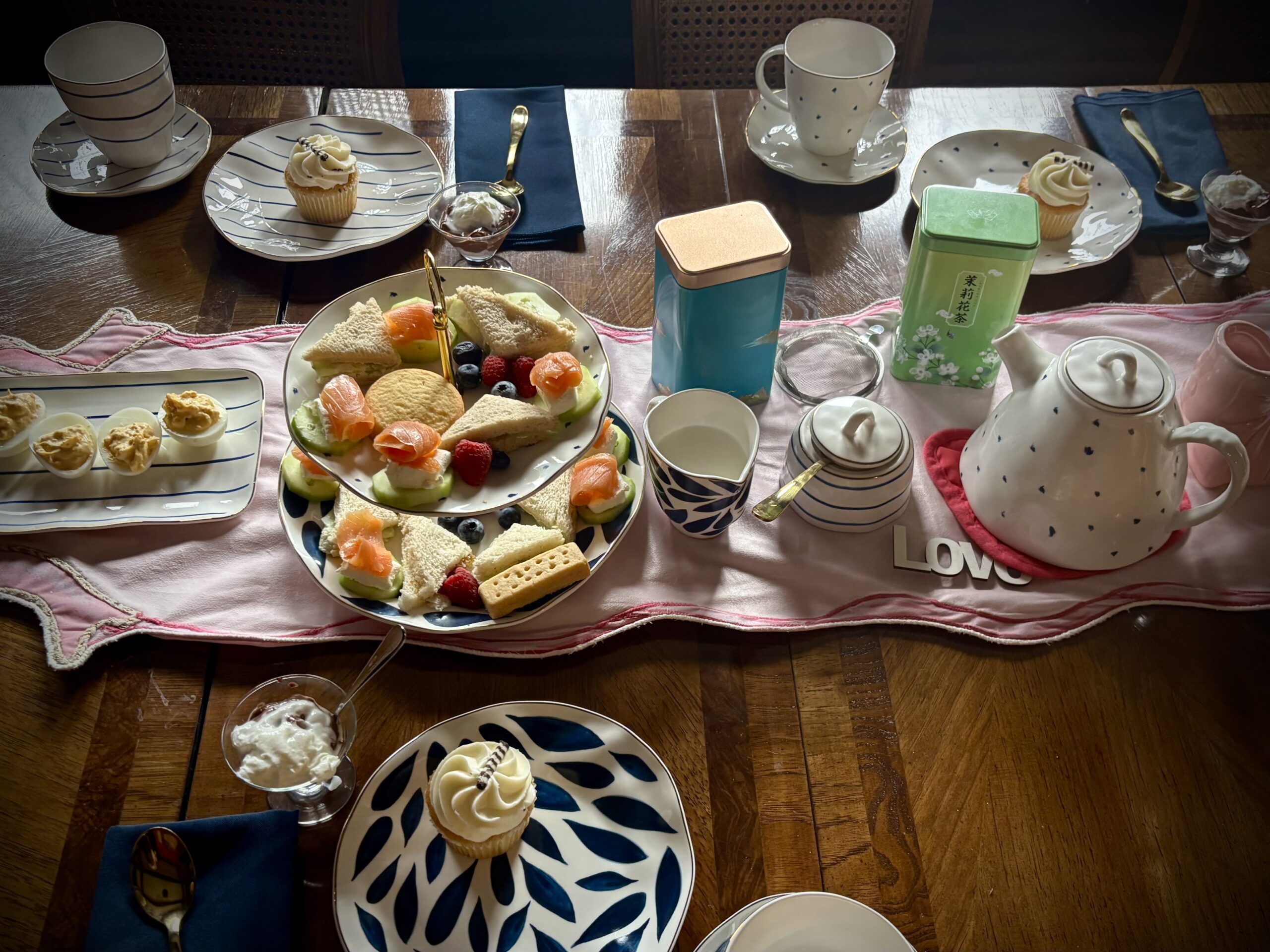 High tea place settings and a tiered tray of sandwiches, smoked salmon, fruit, desserts, and tea at Fears House in Muskogee